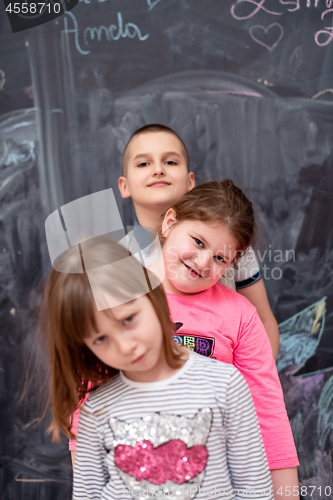 Image of group of kids standing in front of chalkboard