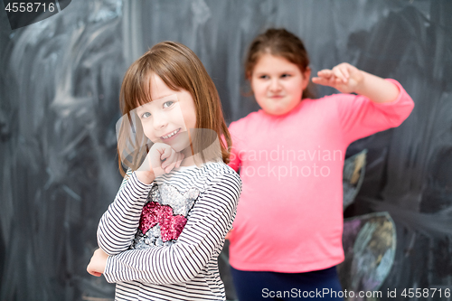 Image of portrait of little girls in front of chalkboard