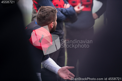 Image of american football player discussing strategy with his team