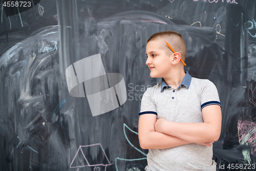 Image of portrait of little boy in front of chalkboard