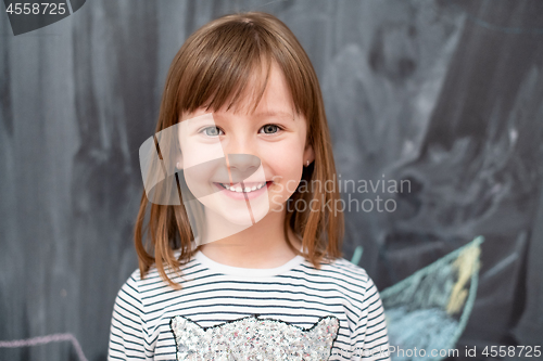 Image of portrait of little girl in front of chalkboard