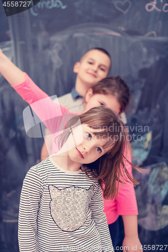 Image of group of kids standing in front of chalkboard