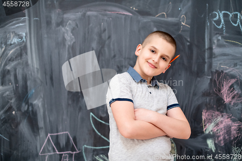 Image of portrait of little boy in front of chalkboard