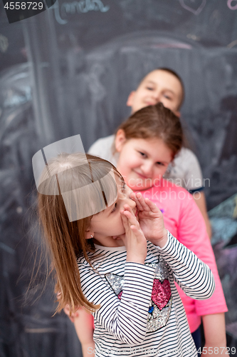 Image of group of kids standing in front of chalkboard