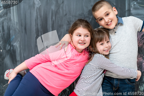 Image of group of kids hugging in front of chalkboard