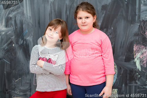 Image of portrait of little girls in front of chalkboard