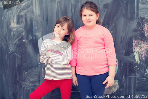 Image of portrait of little girls in front of chalkboard