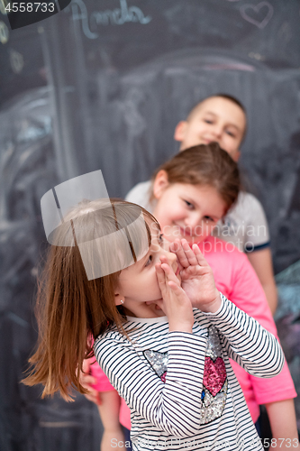 Image of group of kids standing in front of chalkboard