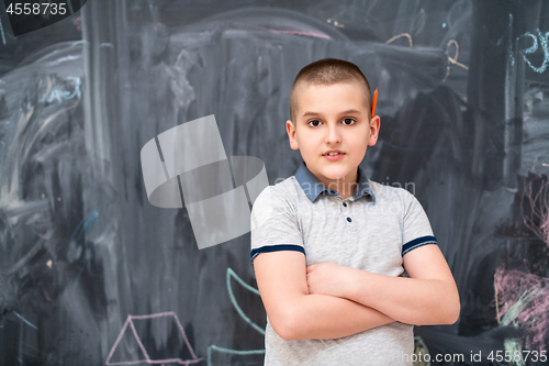 Image of portrait of little boy in front of chalkboard