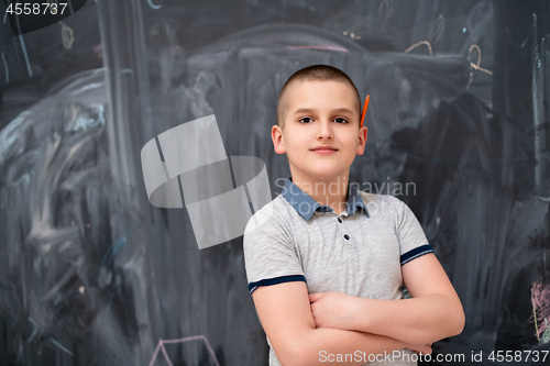 Image of portrait of little boy in front of chalkboard