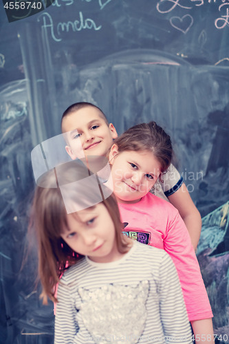 Image of group of kids standing in front of chalkboard