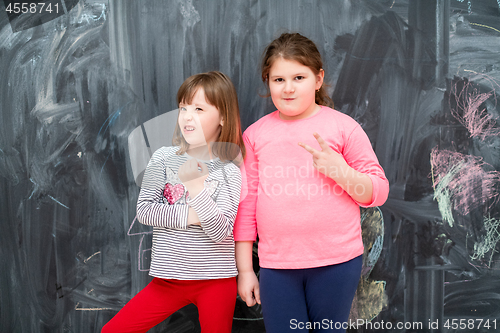 Image of portrait of little girls in front of chalkboard