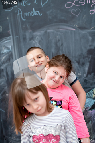 Image of group of kids standing in front of chalkboard