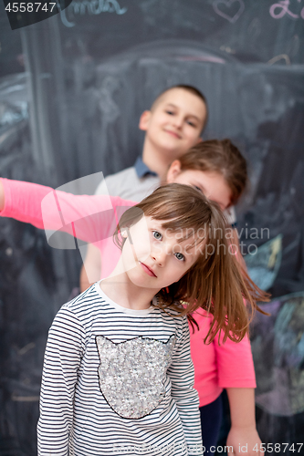 Image of group of kids standing in front of chalkboard