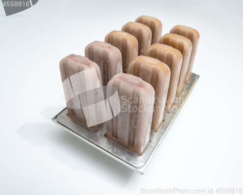 Image of Ice cream lolly coffee in plastic molds on a white background wi