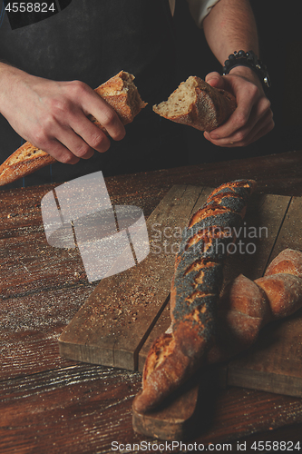 Image of Male hands break the baguette