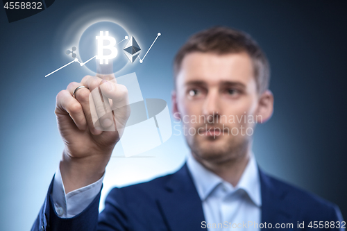 Image of the man clicks Icon Bitcoin on virtual screen.