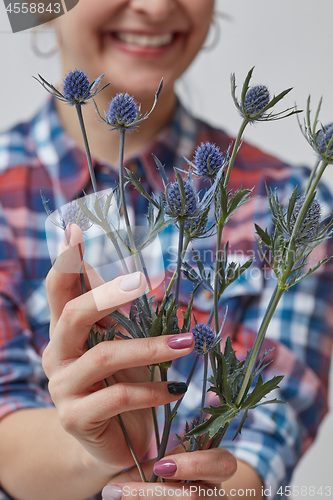 Image of Happy girl holding a flower eryngium