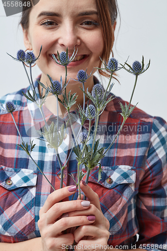 Image of Young girl with flowers eryngium