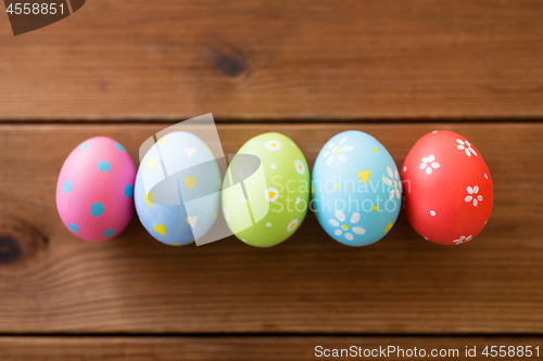 Image of row of colored easter eggs on wooden table