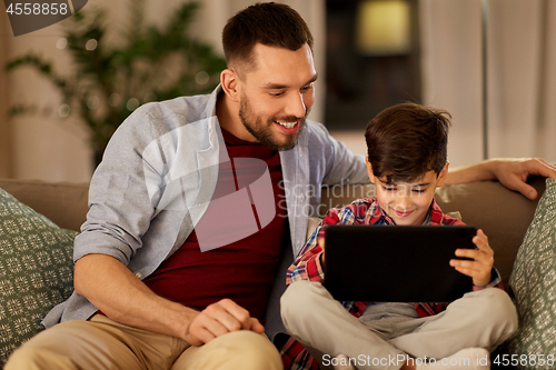 Image of father and son with tablet pc playing at home