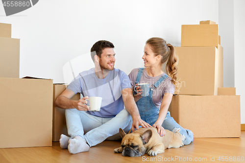 Image of happy couple with boxes and dog moving to new home