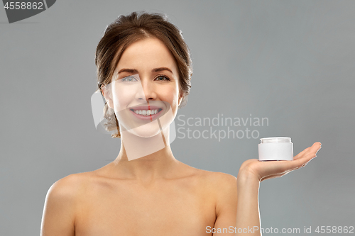 Image of happy young woman holding jar of cream