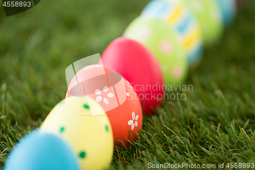 Image of row of colored easter eggs on artificial grass