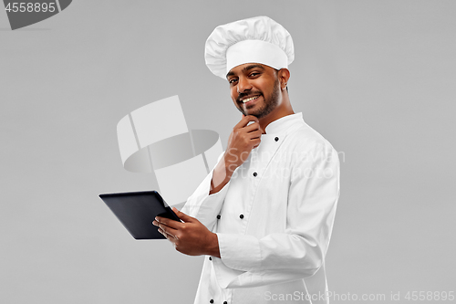 Image of happy male indian chef with tablet computer