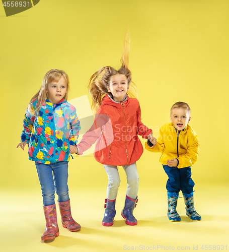 Image of A full length portrait of a bright fashionable kids in a raincoat