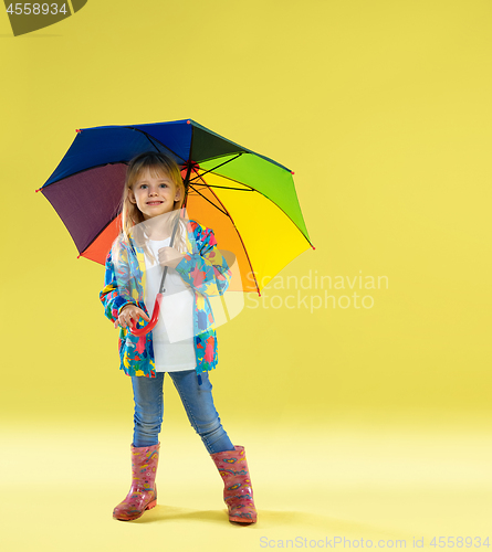 Image of A full length portrait of a bright fashionable girl in a raincoat