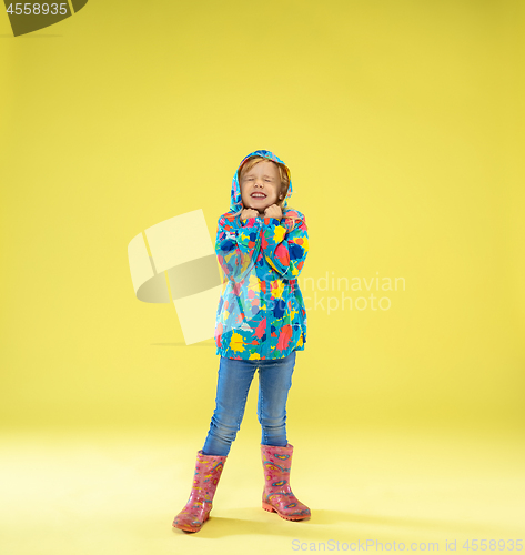 Image of A full length portrait of a bright fashionable girl in a raincoat