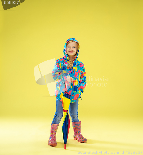 Image of A full length portrait of a bright fashionable girl in a raincoat