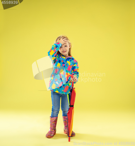 Image of A full length portrait of a bright fashionable girl in a raincoat