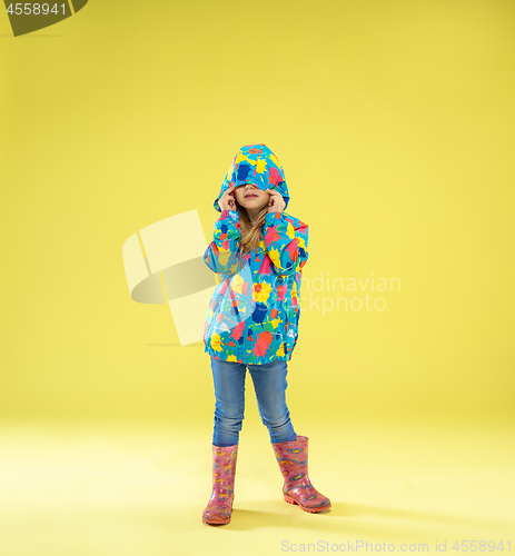 Image of A full length portrait of a bright fashionable girl in a raincoat