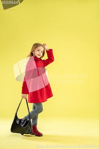 Image of A full length portrait of a bright fashionable girl in a raincoat