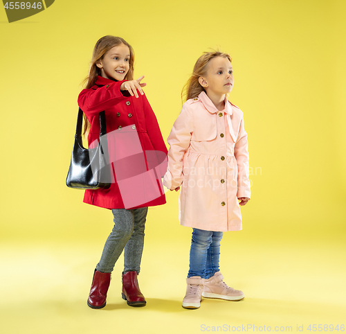 Image of A full length portrait of a bright fashionable girls in a raincoat