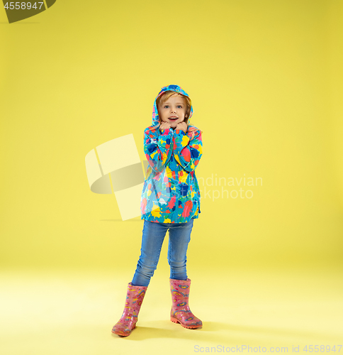 Image of A full length portrait of a bright fashionable girl in a raincoat