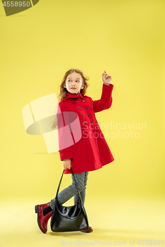 Image of A full length portrait of a bright fashionable girl in a raincoat