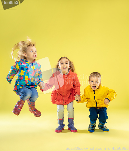 Image of A full length portrait of a bright fashionable kids in a raincoat