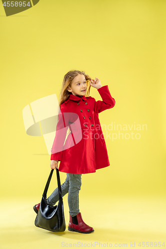 Image of A full length portrait of a bright fashionable girl in a raincoat