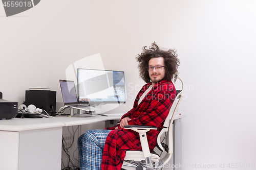 Image of graphic designer in bathrobe working at home