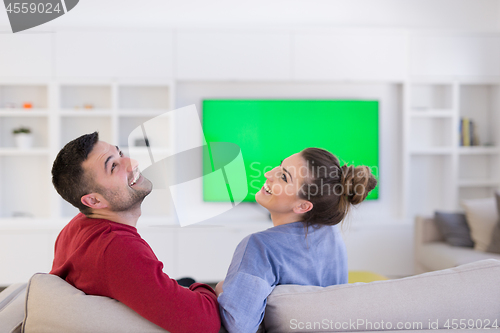 Image of Young couple on the sofa watching television