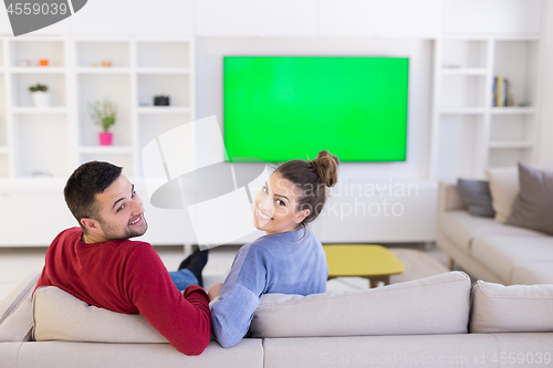 Image of Young couple on the sofa watching television