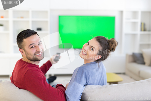 Image of Young couple on the sofa watching television