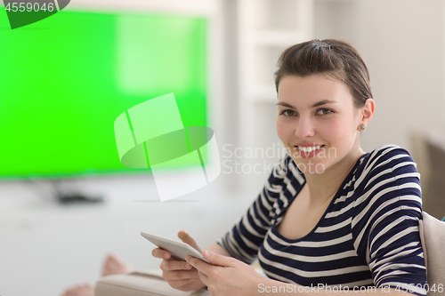 Image of woman on sofa using tablet computer