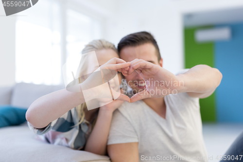 Image of couple making heart with hands