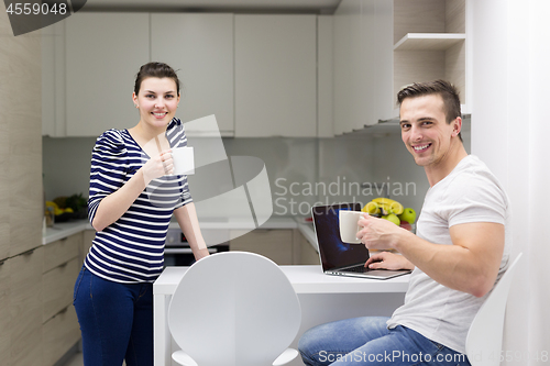 Image of couple with laptop computer enjoying morning