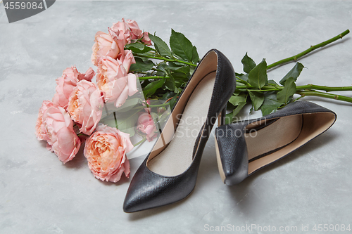 Image of bouquet of pink roses and women\'s shoes