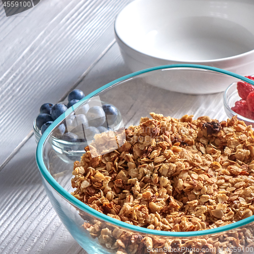Image of Organic homemade Granola Cereal with oats and fresh berries. Texture oatmeal granola or muesli in aglass bowl on a gray background.